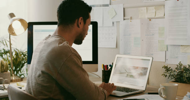 istock Shot of an unrecognisable businessman sitting alone and using his laptop while working from home 1357880709