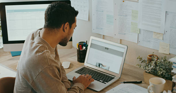 istock Shot of an unrecognisable businessman sitting alone and using his laptop while working from home 1357880747