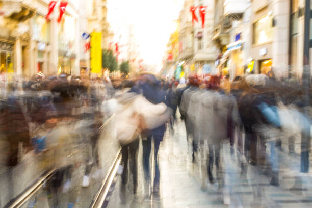 istock Crowd on blur street in bright lens flare 1357881457