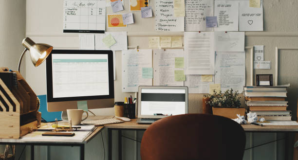 istock Shot of technology and paperwork on a desk in an empty home office 1357881475