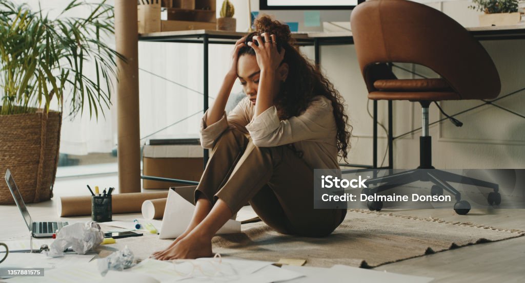 Full length shot of an attractive young businesswoman sitting on the floor in her home office and feeling stressed Why can't I get this right? Failure Stock Photo