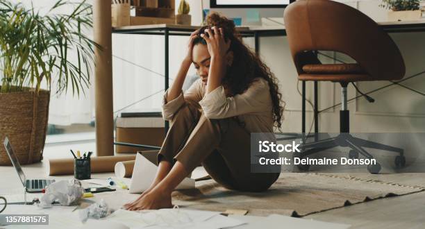Full Length Shot Of An Attractive Young Businesswoman Sitting On The Floor In Her Home Office And Feeling Stressed Stock Photo - Download Image Now