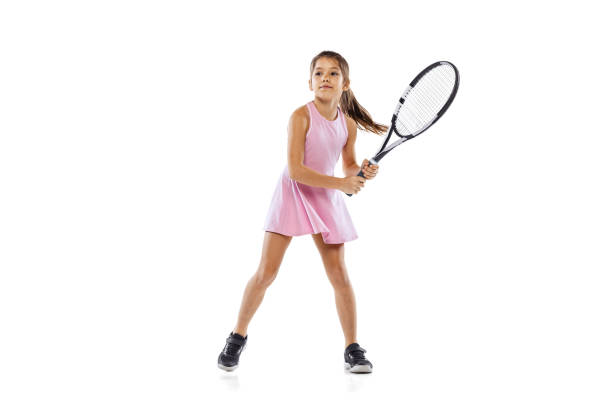 happy sportive petite fille, enfant, joueur de tennis débutant pratiquant isolé sur fond de studio blanc. - tennis ball indoors sport photos et images de collection
