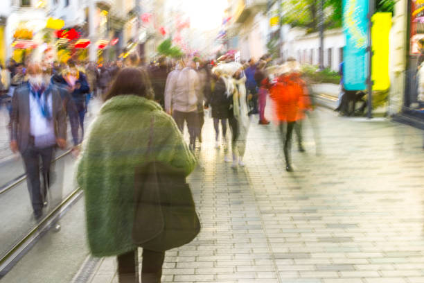 istock Crowd on blur street in bright lens flare 1357882993