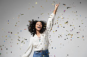 Beautiful excited woman at celebration party with falling confetti