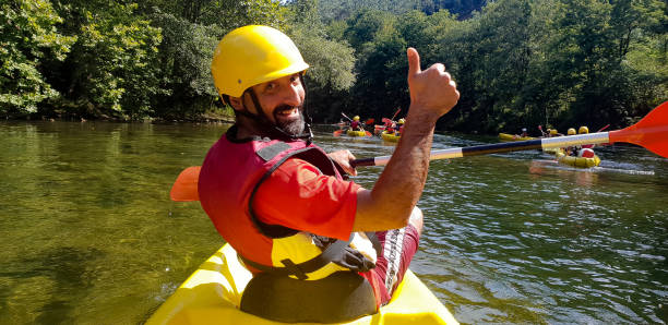istock man kayaking in river waving and smiling 1357884744