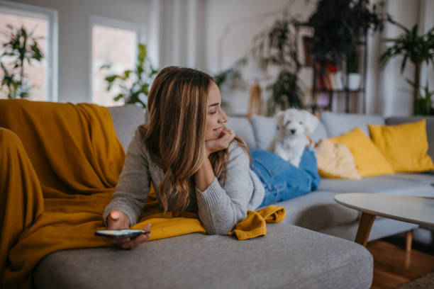 istock Woman relaxing on sofa with dog 1357886517