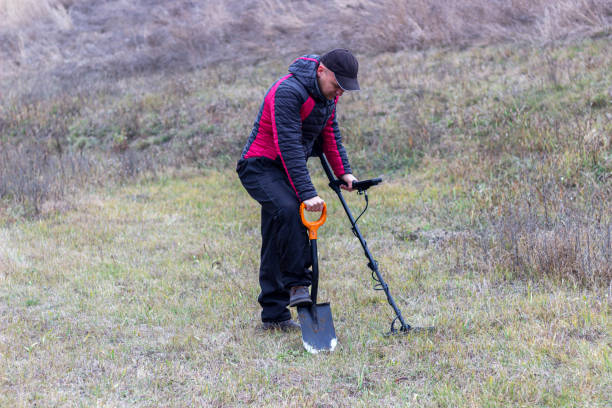 istock A man with a metal detector and a shovel digs a hole 1357888868