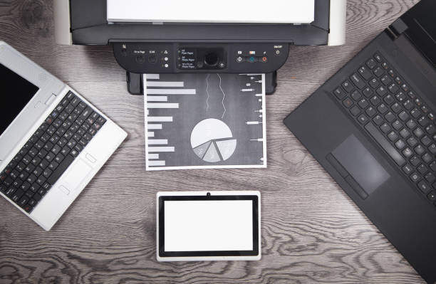 istock Analyzing investment charts with printer and laptop. 1357889576