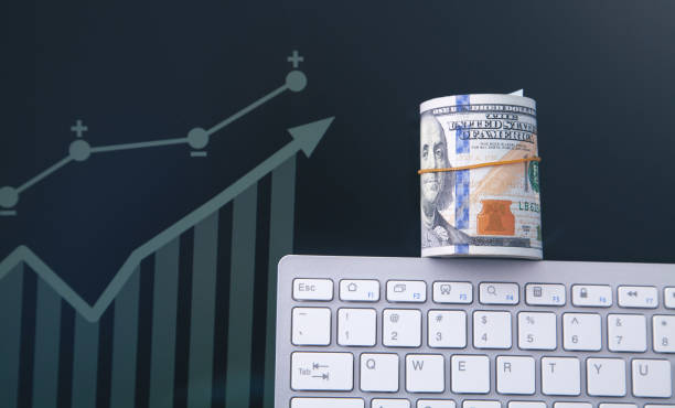 istock Dollar banknotes on the computer keyboard with growth chart in screen. 1357889597