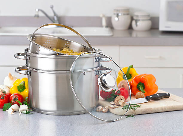 Stainless pasta pot on kitchen counter with fresh vegetables