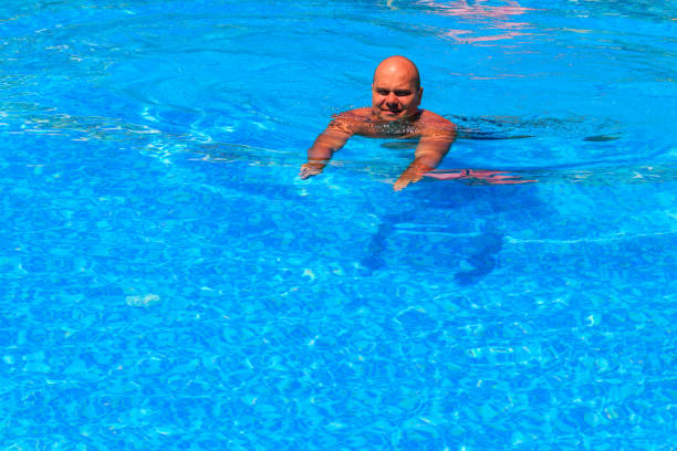 istock Handsome man relaxing in the swimming pool 1357893668