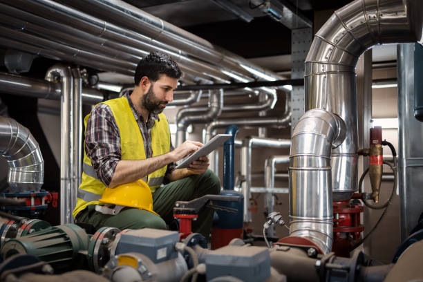 Stationary engineer at work Stationary engineer at work with technician support piping hot stock pictures, royalty-free photos & images