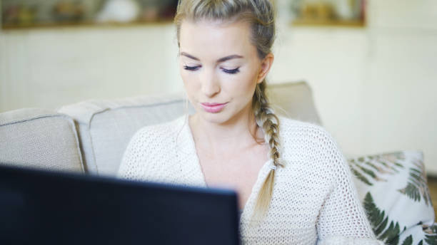 istock Young blonde woman working with computer at home. 1357894029