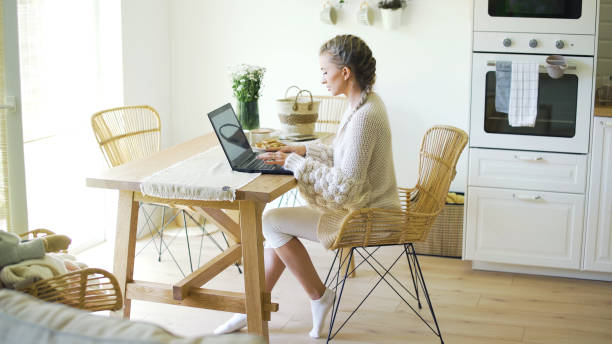 istock Young blonde woman working with computer at home. 1357894051