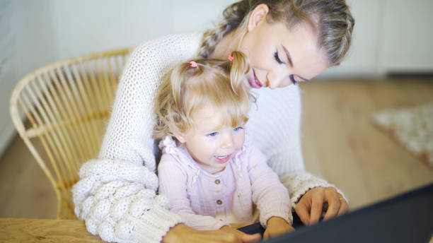 istock Young mother working with her daughter at home. 1357894052