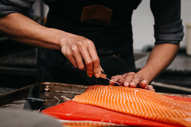 istock The chef using tweezers to remove the salmon pin bones from a salmon fillet 1357895268