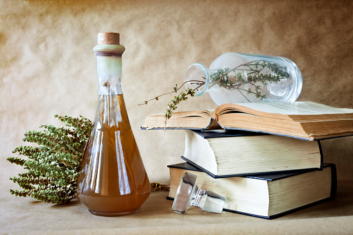 Herbs in alternative medicine with books on vintage background ,still life