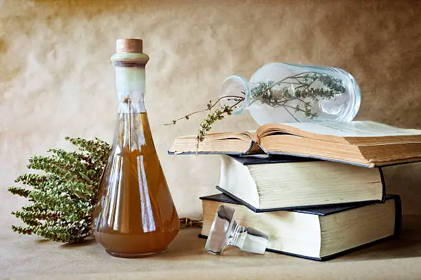 Herbs in alternative medicine with books on vintage background ,still life