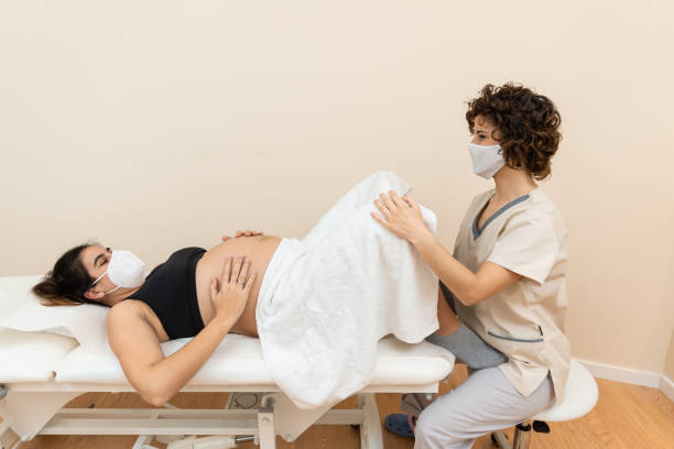 gynécologue examinant et effectuant un traitement du plancher pelvien sur une femme caucasienne enceinte - torso physical therapy patient relaxation exercise photos et images de collection