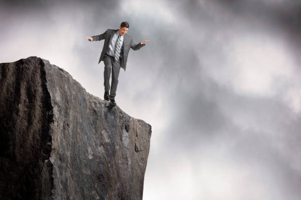 istock Man Balances At The Edge Of A Cliff 1357899307