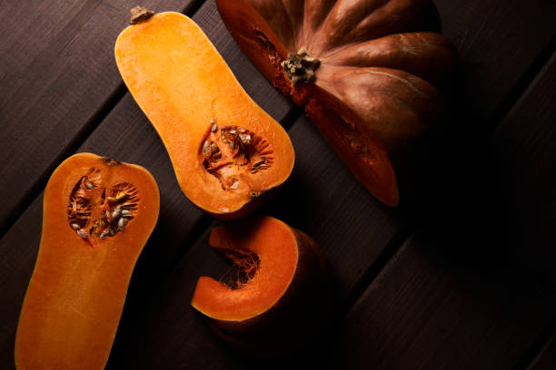 istock Two different sliced ripe orange pumpkins closeup wooden background 1357899540