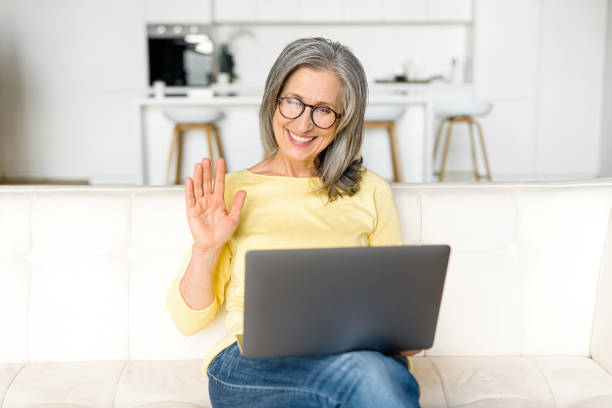 istock Video call concept. Happy senior woman using laptop computer for video connection 1357899615