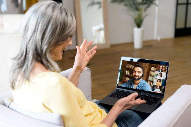 istock Gray-haired senior woman using online platform for online communication with colleagues 1357899680