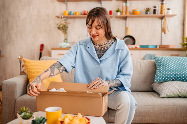 istock Woman unpacking the package she ordered online 1357900498