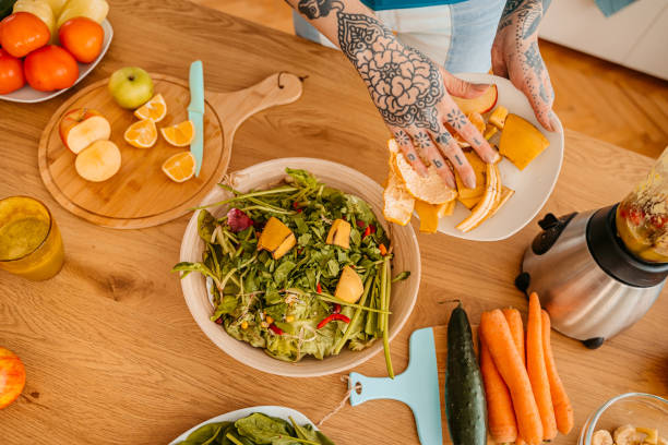 istock Woman collecting fruit and vegetable leftovers for compost 1357902089