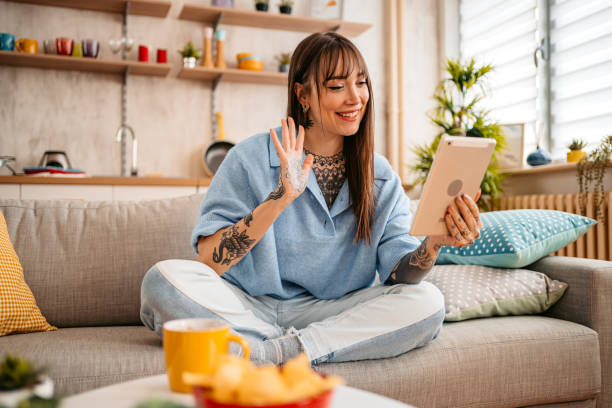istock Tattooed woman having video call on tablet 1357902999