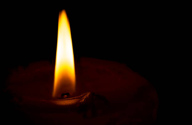 istock Burning candle flame on black background 1357903058