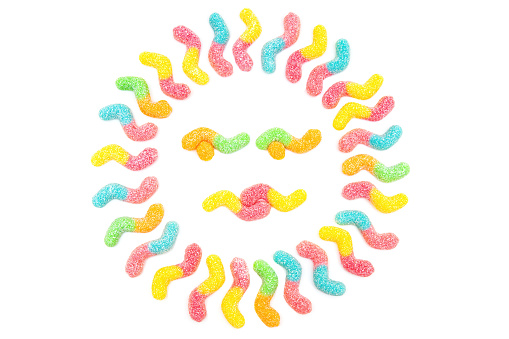Sun symbol made from sugar coated gummy worms isolated on white background