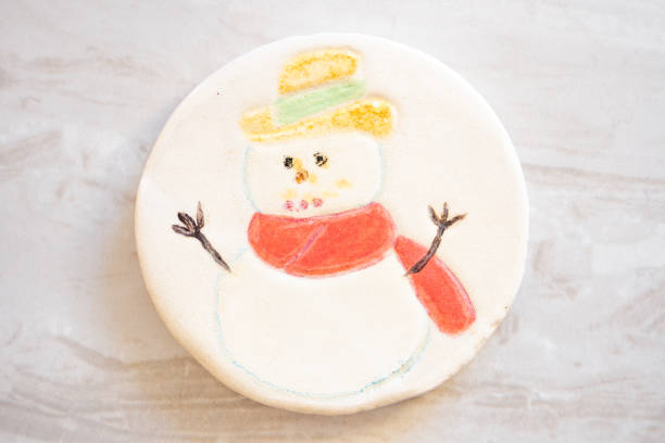 Ceramic Christmas Decoration Coaster with a snowman yellow hat and red scarf on a White Background stock photo
