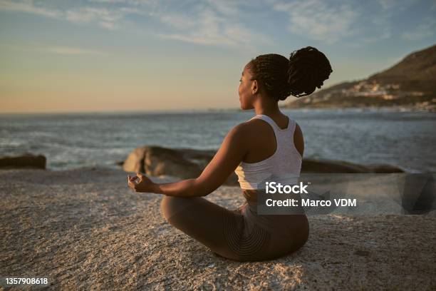 Full Length Shot Of An Attractive Young Woman Practising Yoga On The Beach Stock Photo - Download Image Now