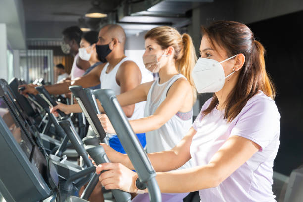 istock Woman training on elliptical trainer at gym 1357913148
