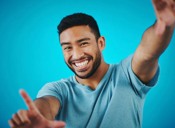 istock Shot of a handsome young man posing against a blue background 1357914675