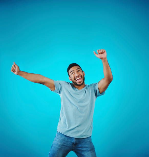 istock Shot of a handsome young man dancing against a blue background 1357914677