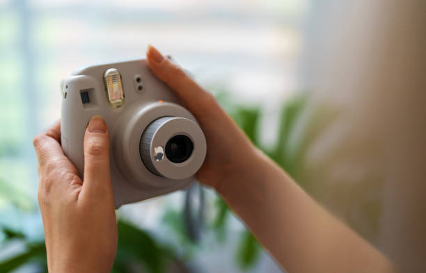 Woman doing selfie photo with instant camera.