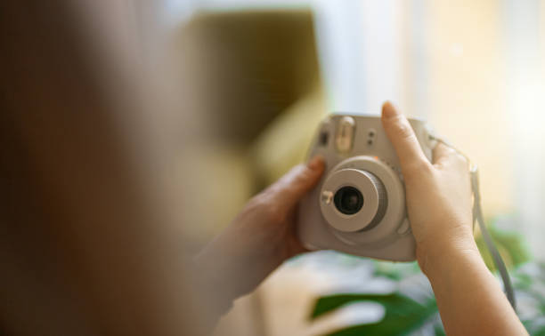 istock Woman doing selfie photo with instant camera. 1357916860