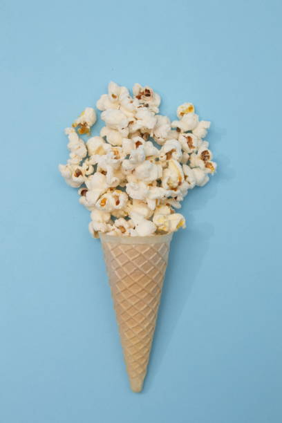 istock Popcorn ice cream in a cone on a light blue background. minimal flat lay scene. 1357917273