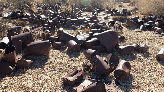 Weathered tin cans in arid landscape