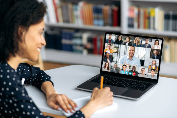 istock Video call, online conference using app and laptop. African American female student, studying remotely, watches an online lecture, taking notes, multiracial smiling people on laptop screen 1357921510