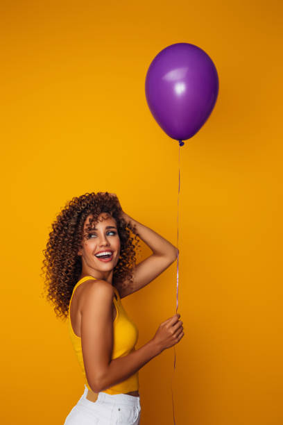 istock Beautiful woman holding a balloon 1357922495