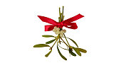 Red bow tied on a bunch of mistletoe with white berries and green leaves