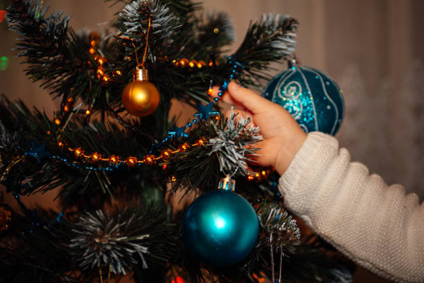 istock child decorates a Christmas tree 1357927297