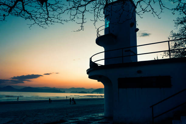 santos, brasil. puesta de sol en la playa y silueta del edificio de la estación de rescate. - lifeguard orange nature beach fotografías e imágenes de stock