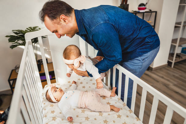 istock Father having fun wit his daughters in the crib 1357928337