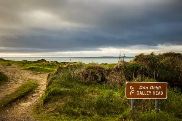 View of Galley Head brown sign with sea background during golden hour.