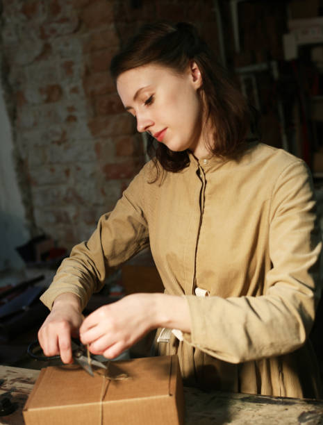 istock young woman folds packing box in sewing workshop 1357928904